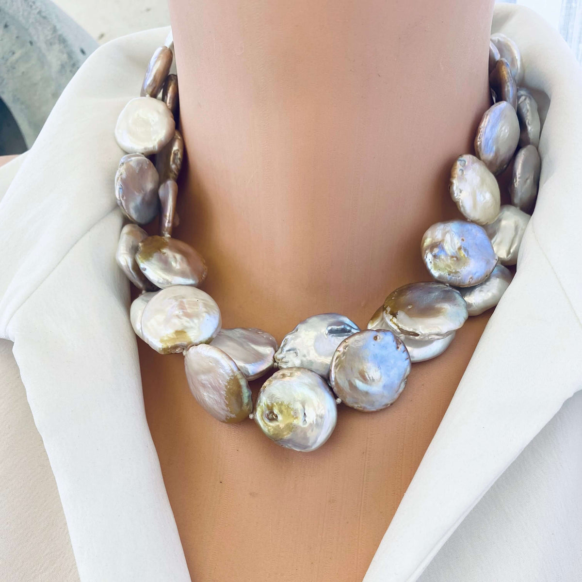 Large coin pearl necklace doubled on mannequin neck, layered statement look