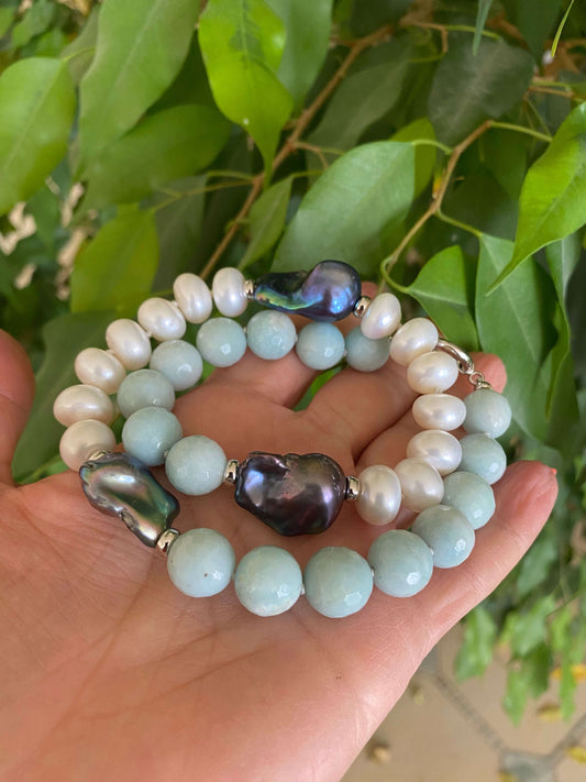 Amazonite pearl necklace with baroque and coin pearls displayed on a hand, showcasing vibrant colors and unique textures.