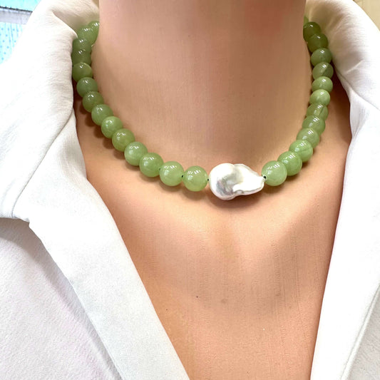 Necklace with green beads and a shell pendant on a white shirt