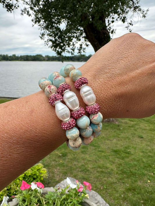 Blue opal jasper bracelet worn on female wrist by lake and trees