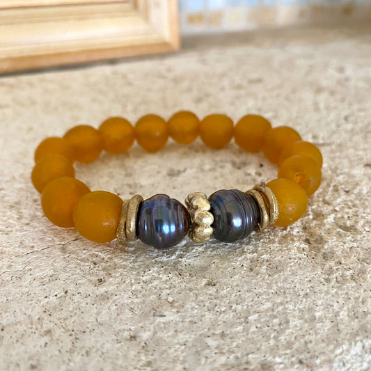 Black pearl bracelet with tangerine African recycled glass, featuring irregular black pearls and vibrant glass beads.