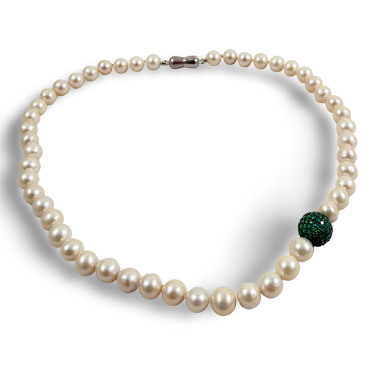 Pearl necklace with green CZ bead, handcrafted elegance featuring white freshwater pearls and vibrant emerald green side piece.