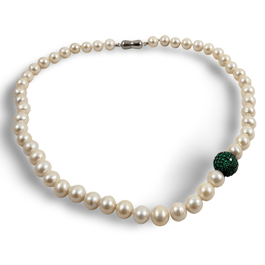 Pearl necklace with green CZ bead, handcrafted elegance featuring white freshwater pearls and vibrant emerald green side piece.