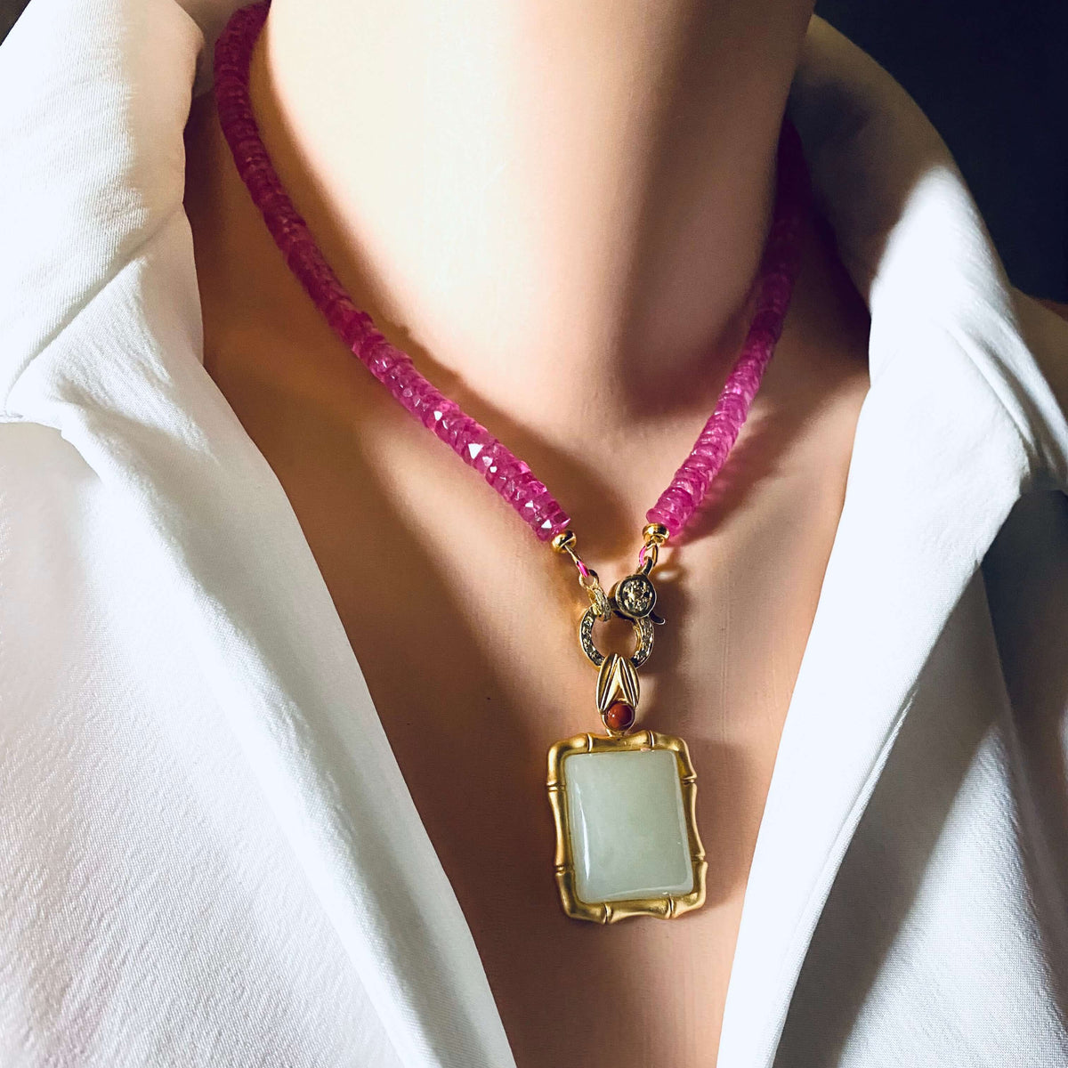 Pink topaz beaded necklace with gold vermeil pavé clasp worn on a model's neck, showcasing vibrant color and elegance.