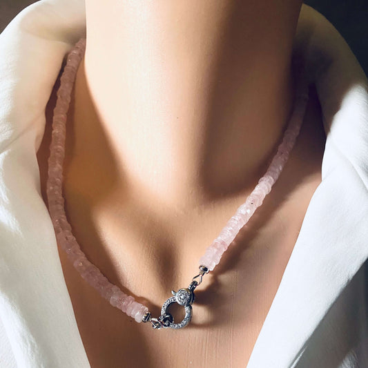 Rose quartz beaded necklace with oxidized silver pavé clasp displayed on a mannequin wearing a white shirt.