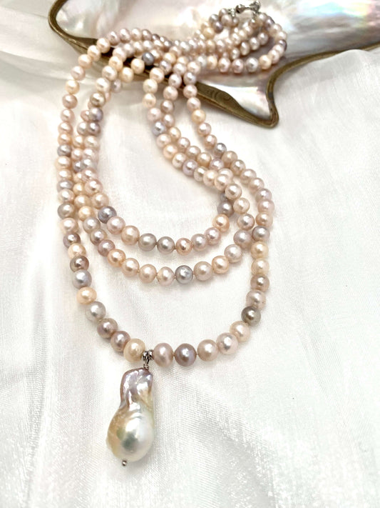Pearl necklace with a pendant on a white fabric background