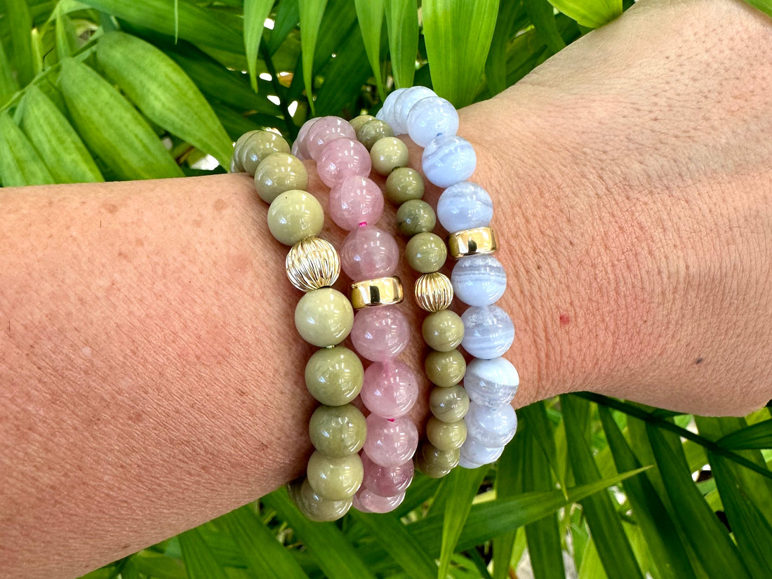 Close-up of stacked gemstone bracelets on a wrist, showcasing seasonal trends in stacking gemstone bracelets.
