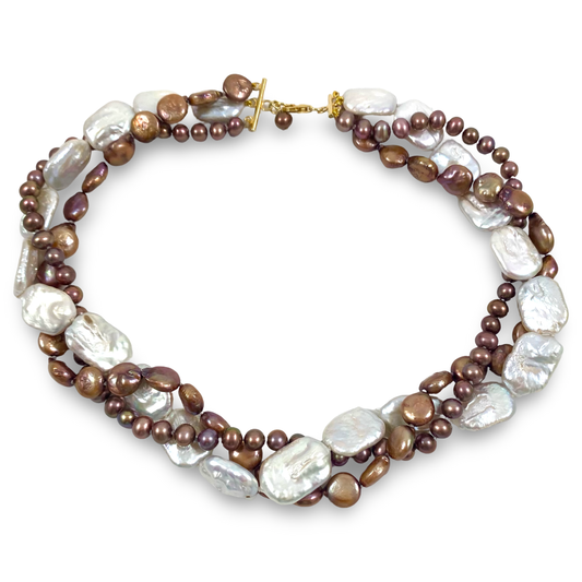 A multi-strand baroque pearl necklace with mixed brown and white pearls, accented by small metallic brown beads and a gold clasp, shown on a plain white background.