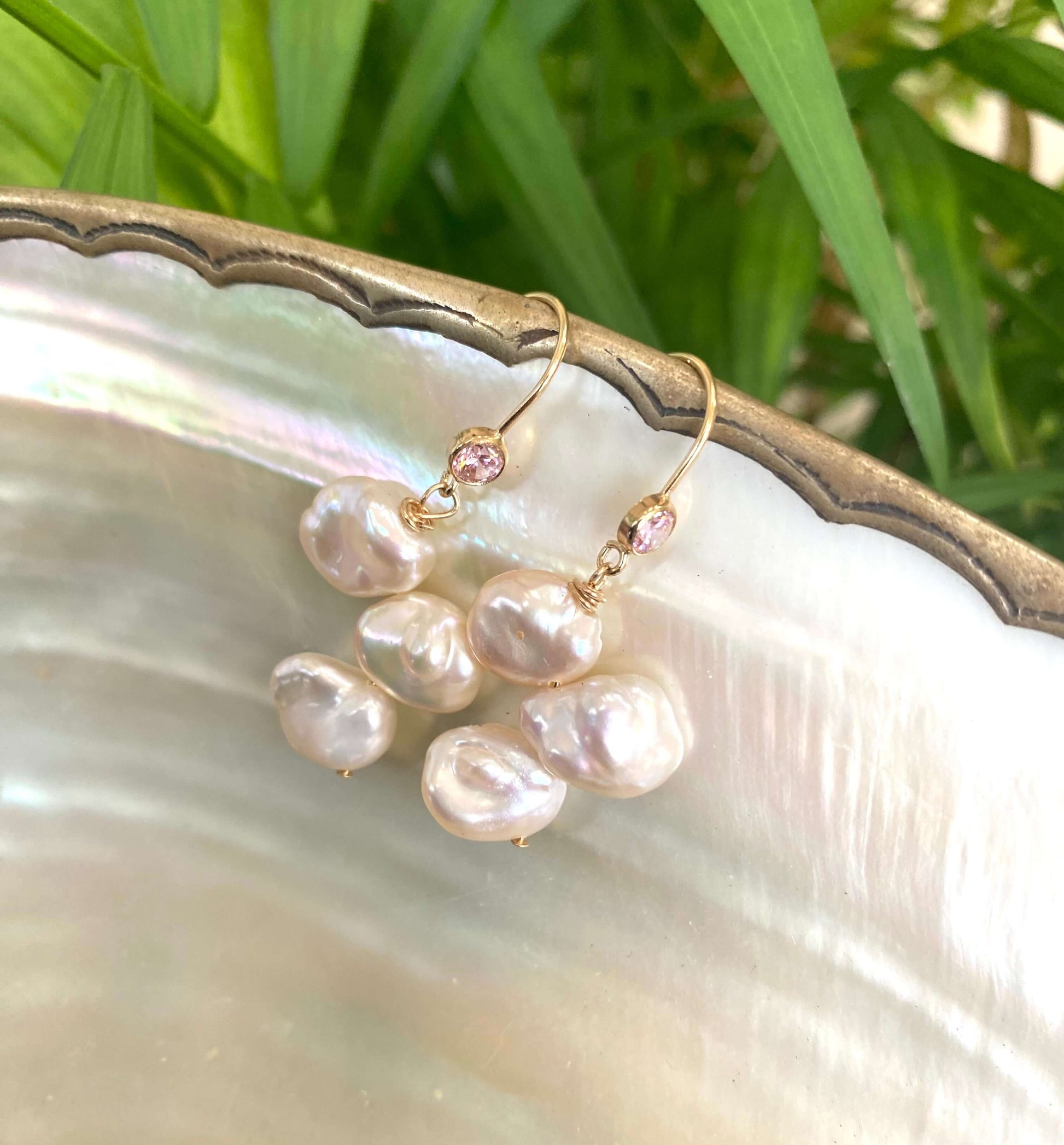 Elegant earrings composed of Natural Keshi pink and white pearls hanging from gold filled hooks with pink cubic zirconia bezel
