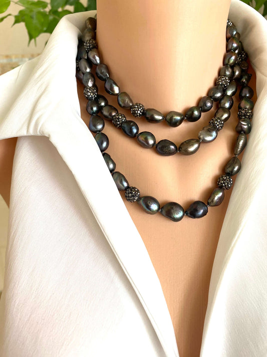 Very long peacock pearl necklace with rhinestone spacer beads showcased on a mannequin against a light background.
