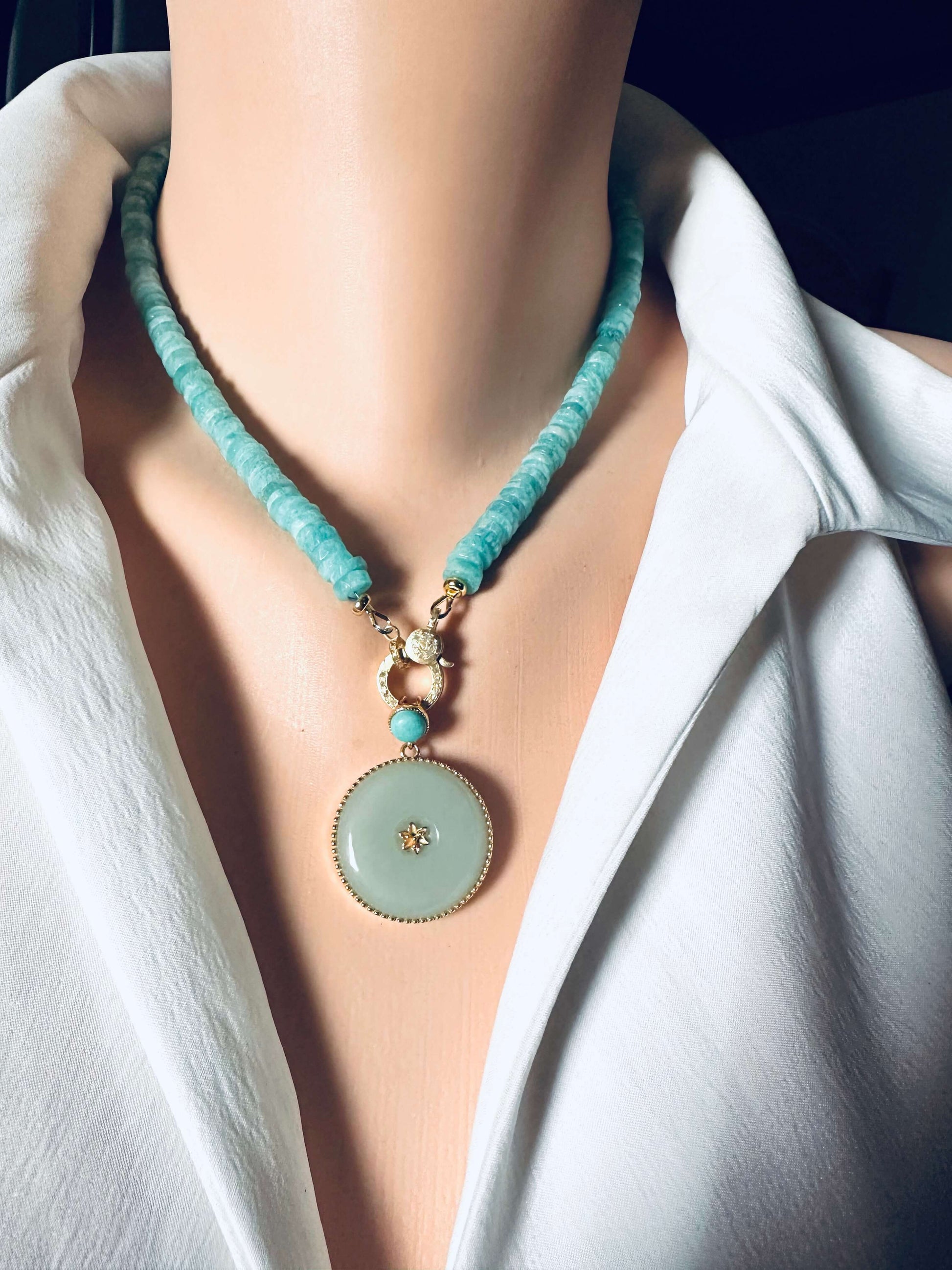 Blue amazonite gemstone necklace with a gold clasp and round pendant, showcasing calming ocean-blue tones and unique design.