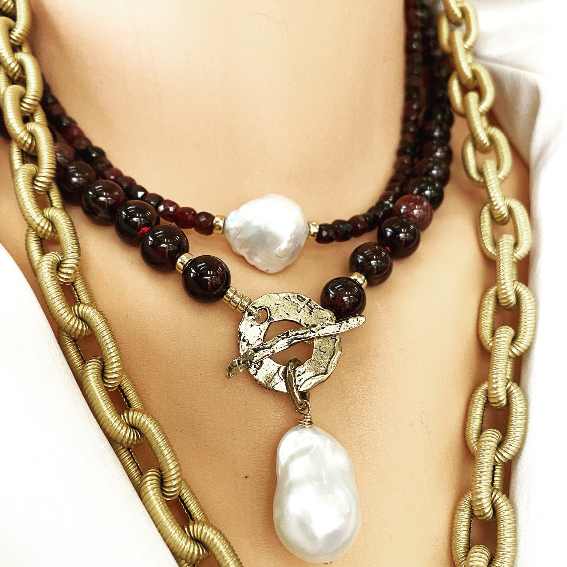 Garnet pearl necklace layered with gold chain featuring baroque pearl pendant