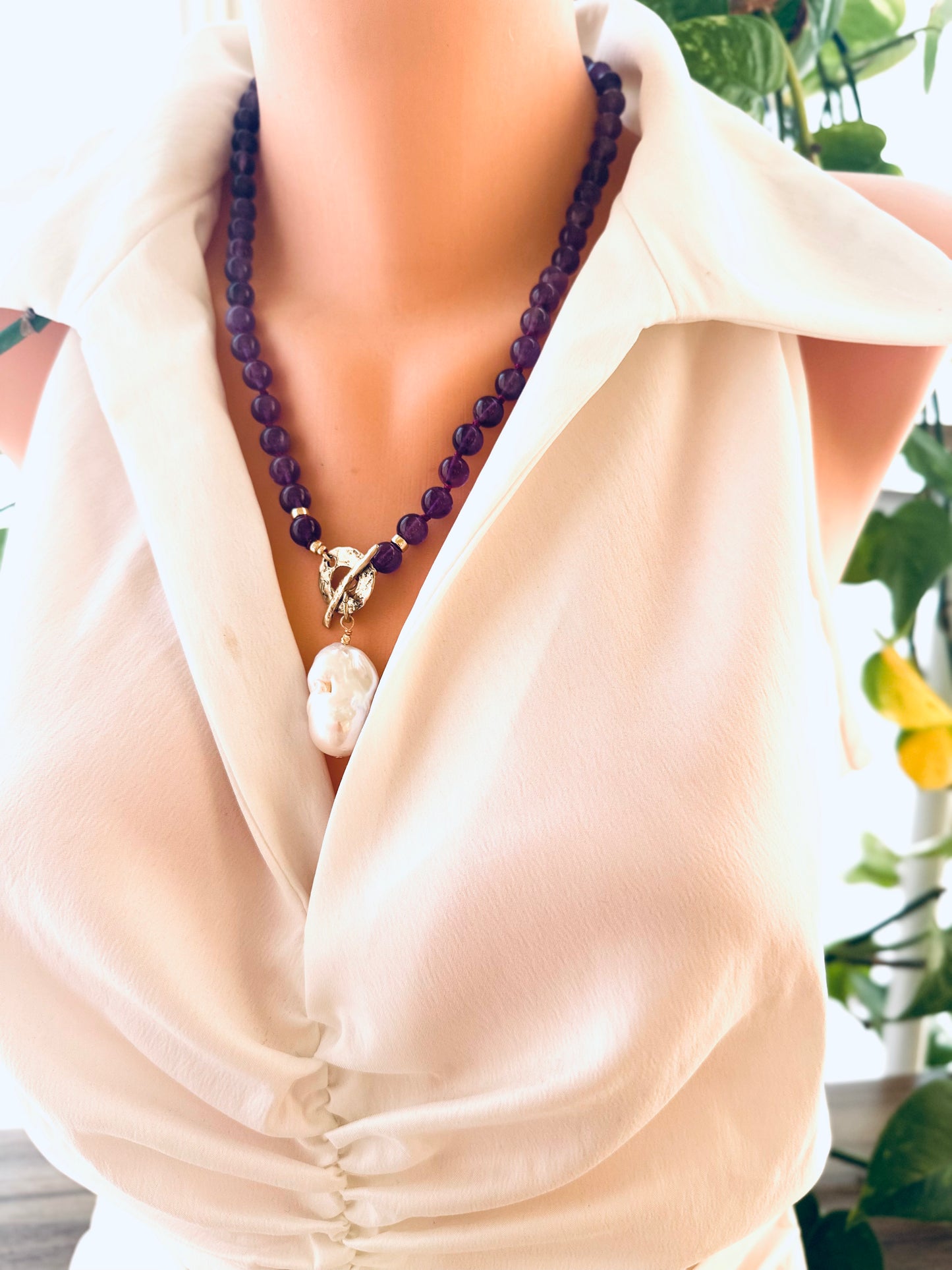 Amethyst toggle necklace layered with other necklaces, featuring baroque pearl pendant