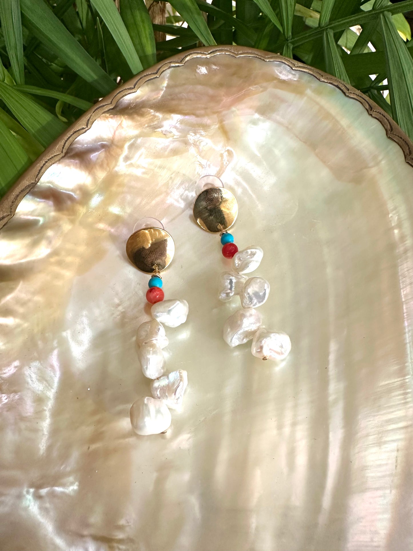 Close view of Baroque Keshi Pearl Earrings on white shell backdrop, highlighting irregular pearls and turquoise stones