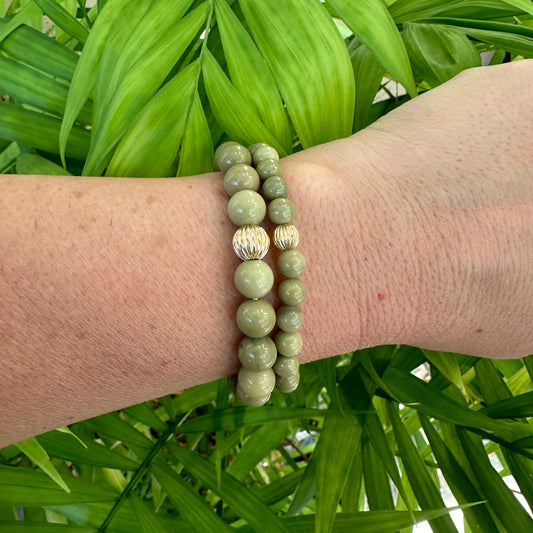 Green Olivine Jasper Bracelet worn on wrist against green leaves – outdoor detail