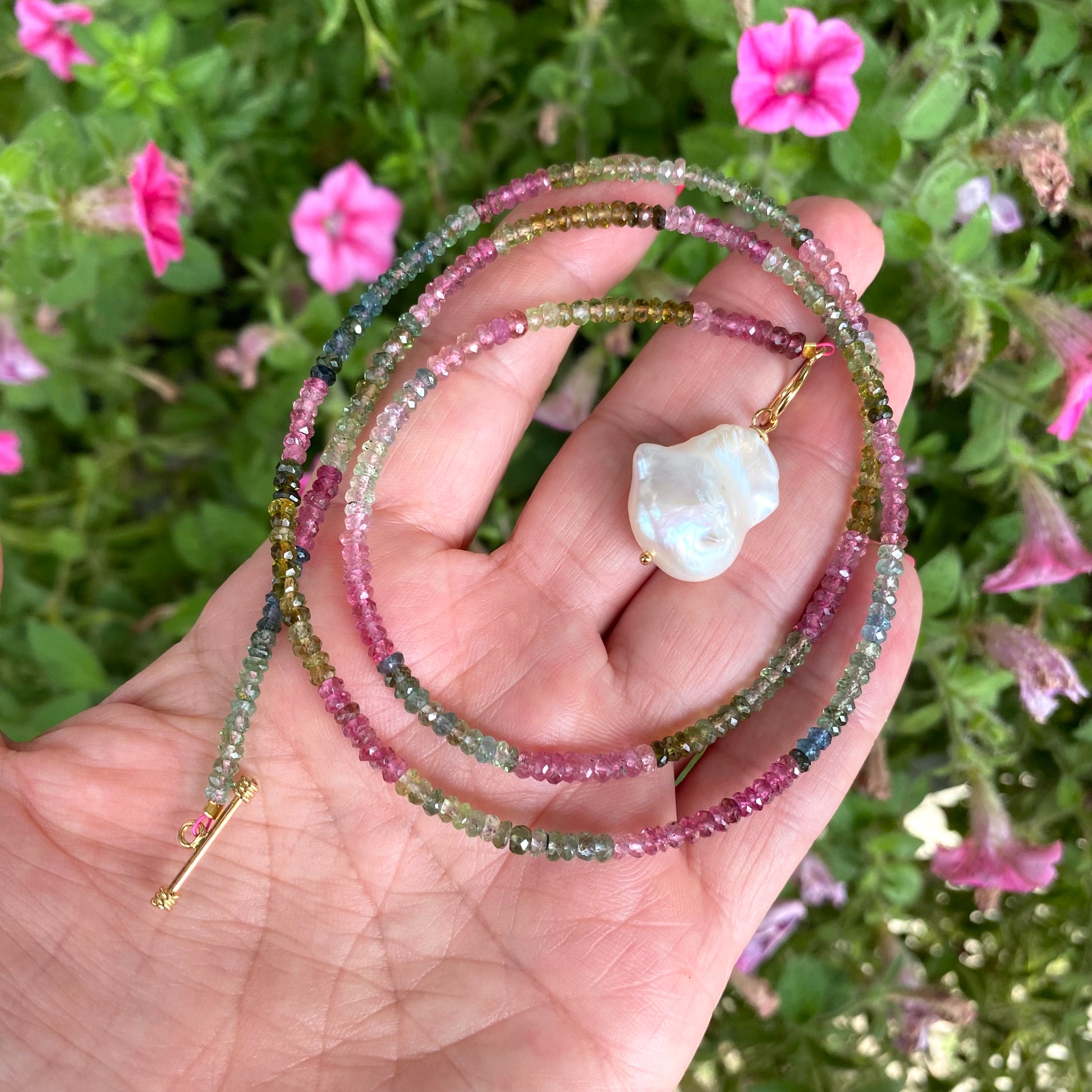 Tourmaline baroque pearl toggle necklace held in hand showing multicolor tourmaline beads