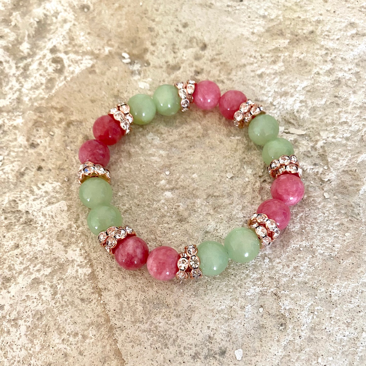 Colorful jade rhinestone stretchy bracelet with red and green jade beads displayed flat