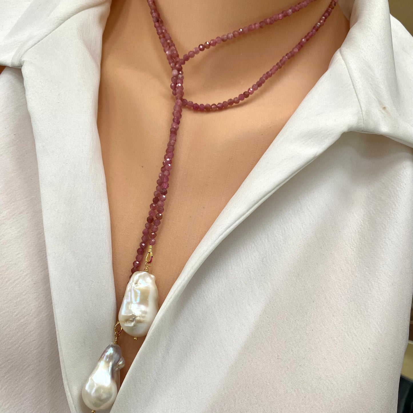 Pink Tourmaline Pearl Lariat Necklace featuring pink tourmaline beads and large baroque pearls against a white shirt.
