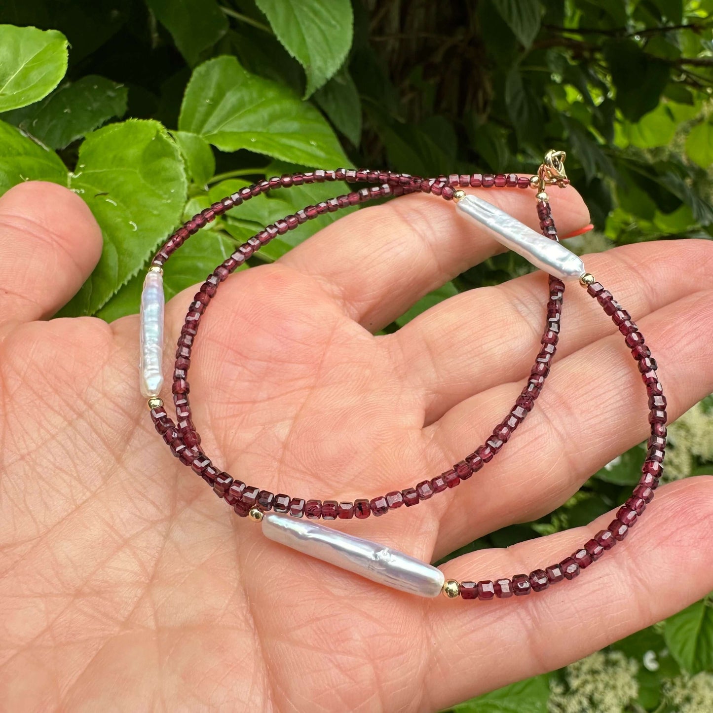 Garnet pearl necklace featuring red faceted garnet beads and luminous Baroque pearls, elegantly handcrafted.
