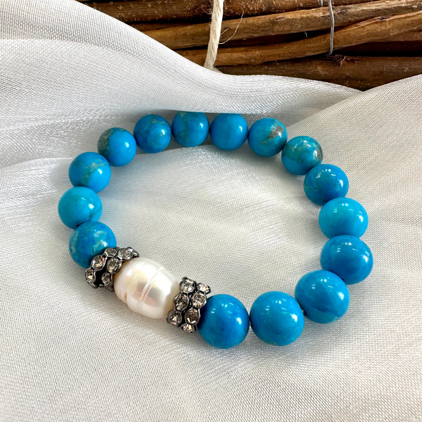 Turquoise howlite pearl bracelet displayed on white cloth