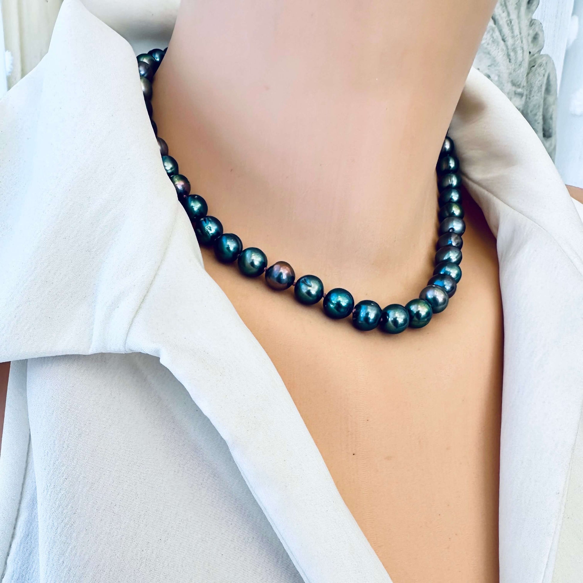 Peacock pearl necklace on mannequin, side angle view