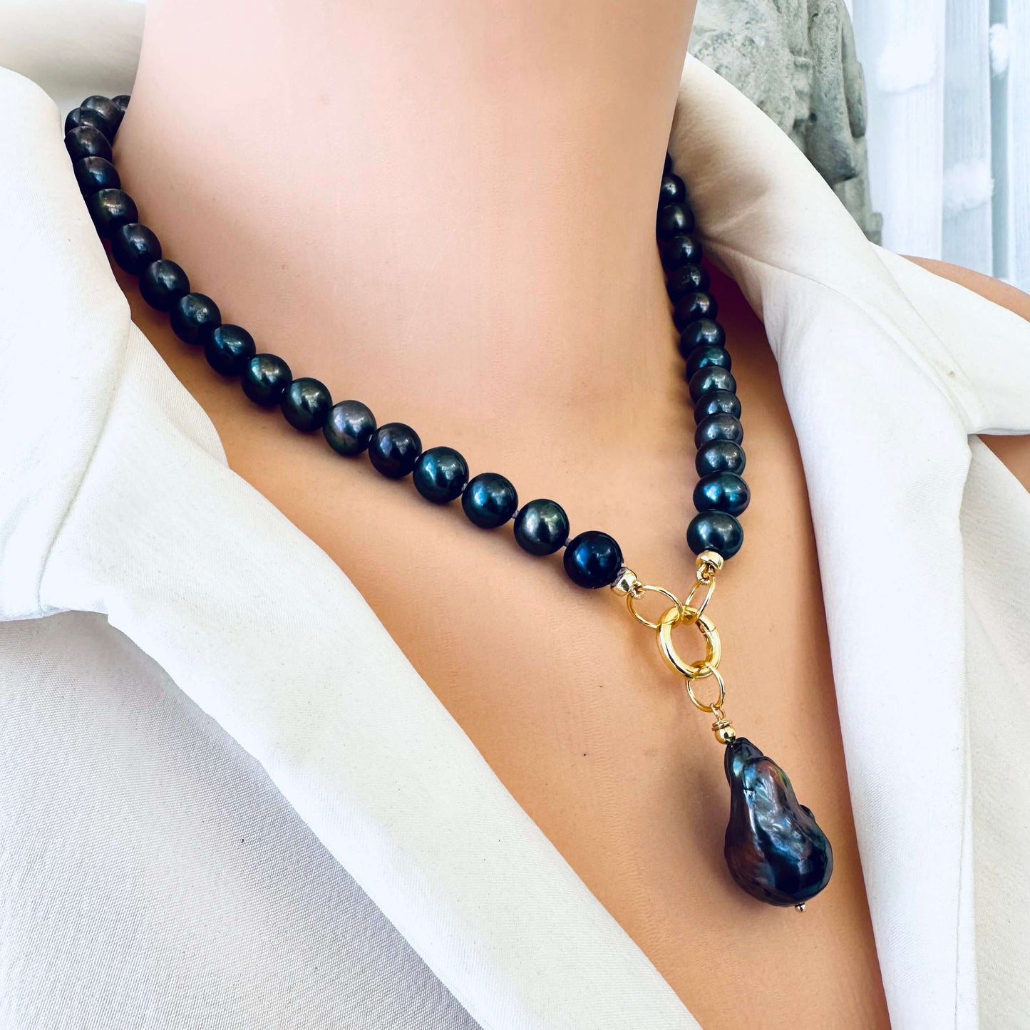 Side close-up of black pearl necklace with baroque pendant on mannequin