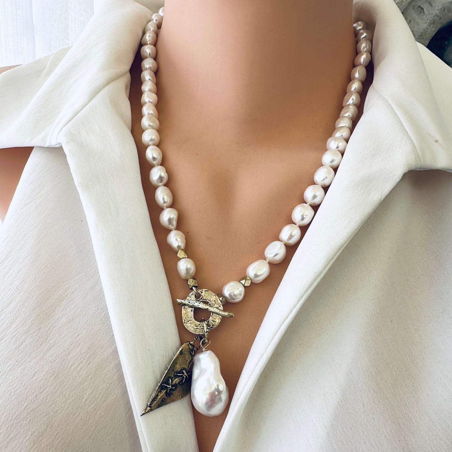 Front view of pearl toggle necklace with heart pendant on mannequin