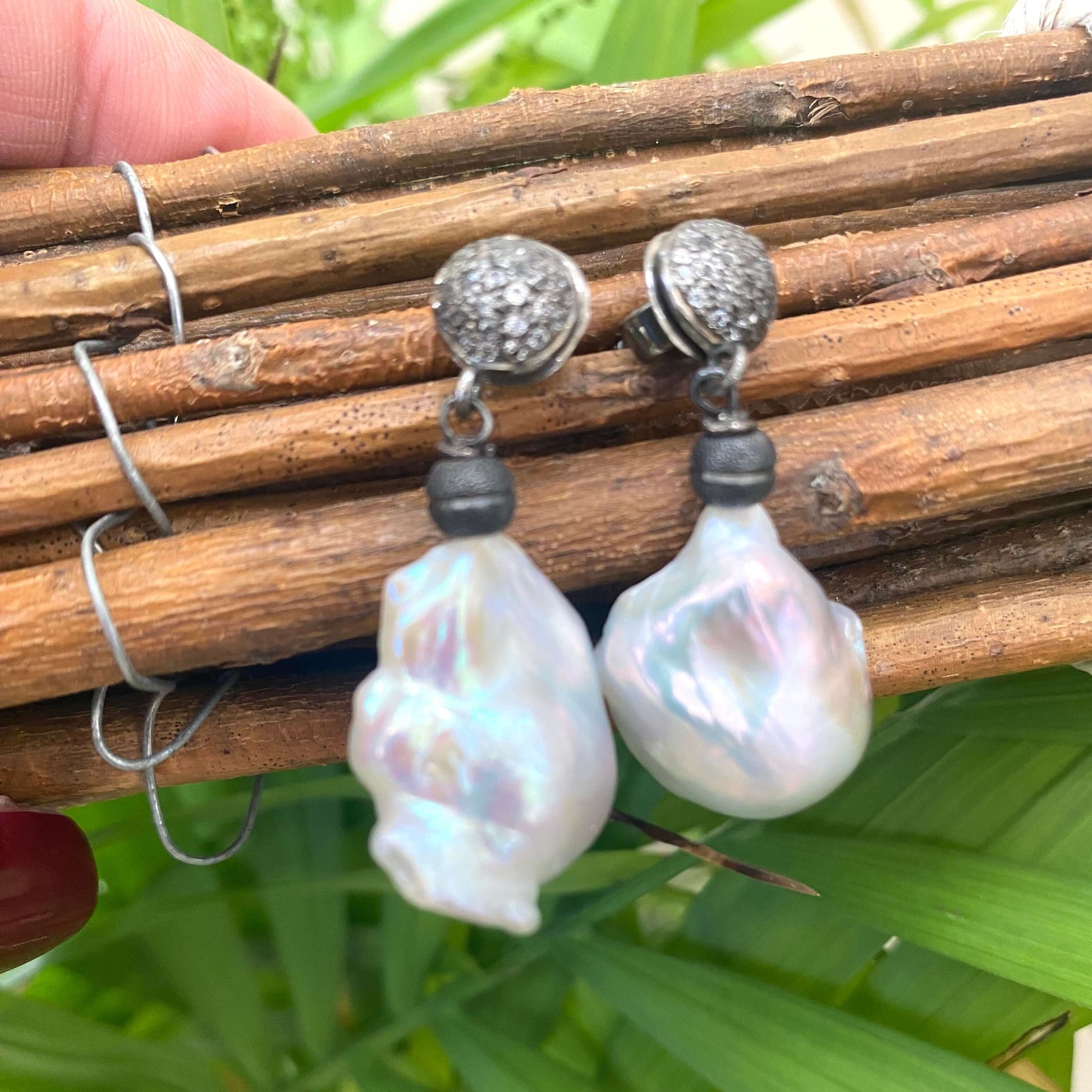 Baroque pearl drop earrings featuring diamond pavé studs in oxidized silver with a lustrous finish.