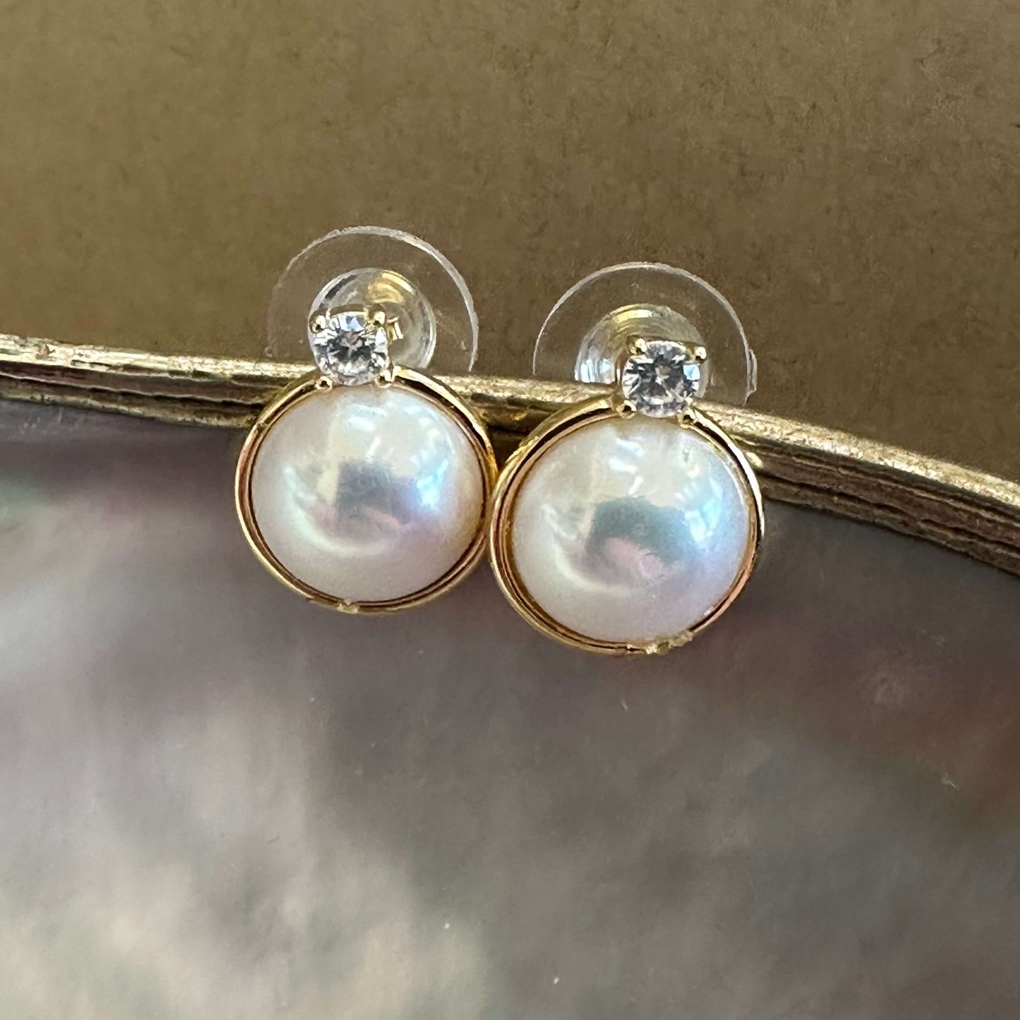 Gold vermeil Mabe Edison pearl stud earrings with CZ accents on beige background