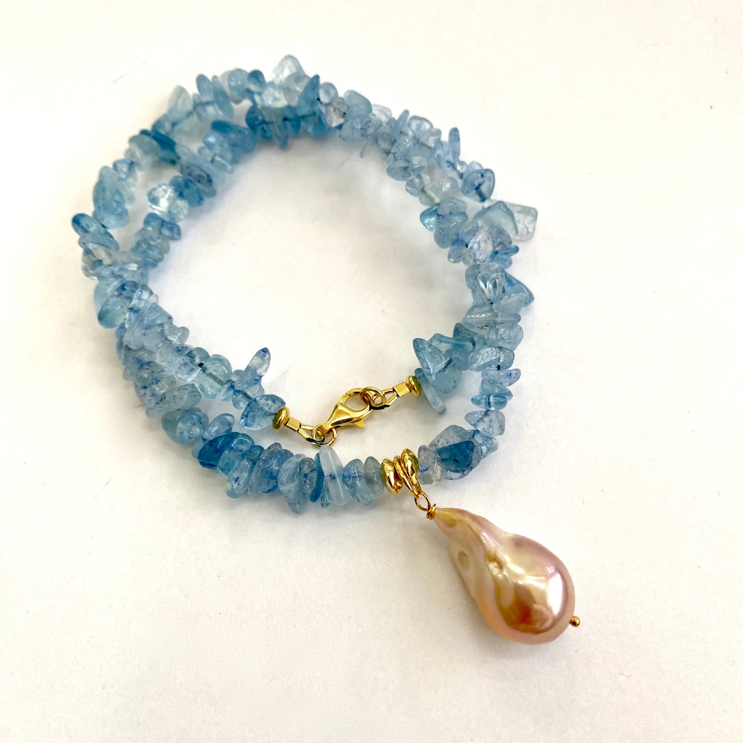 Aquamarine baroque pearl necklace featuring aquamarine gemstones and a golden pink Baroque pearl pendant.