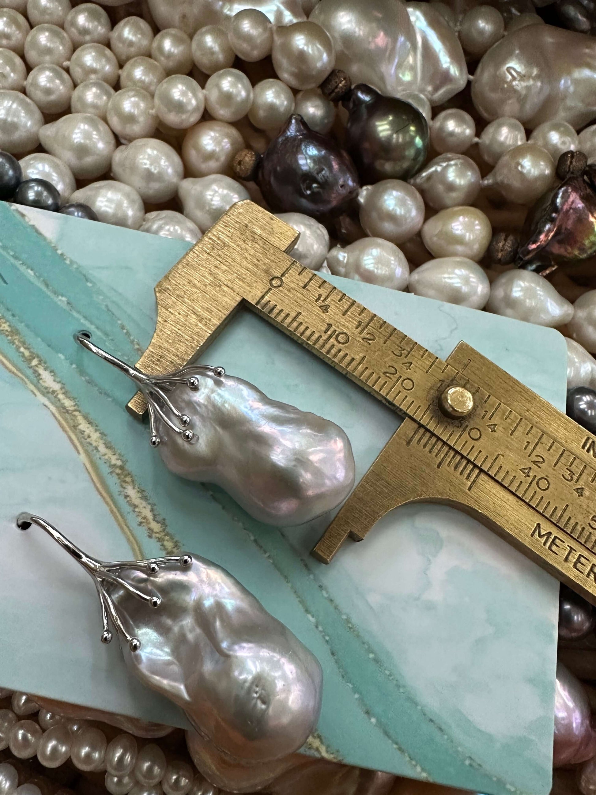 Silver grey baroque pearl drop earring pearl measured against ruler to show size and organic shape of natural freshwater pearl.