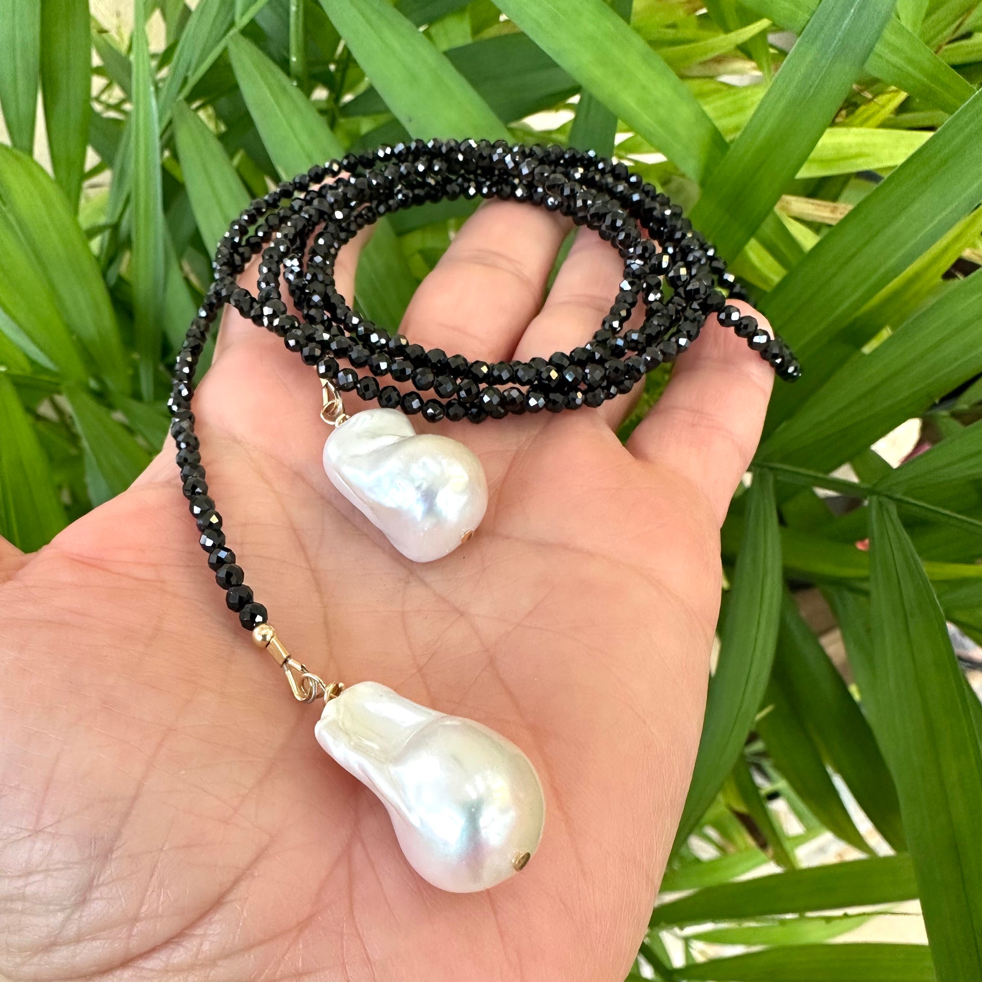 Black spinel lariat necklace with baroque pearl, handmade in Canada, showcasing elegance and light-catching sparkle.
