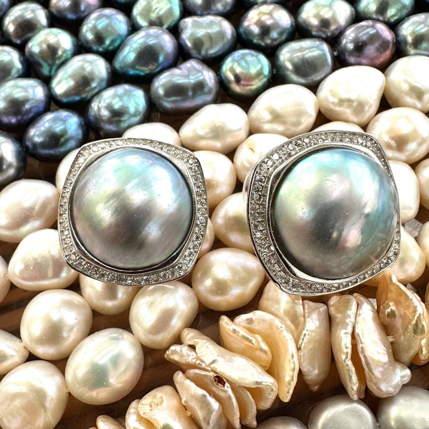 Mabe Pearl Earrings – displayed against colorful gemstone backdrop
