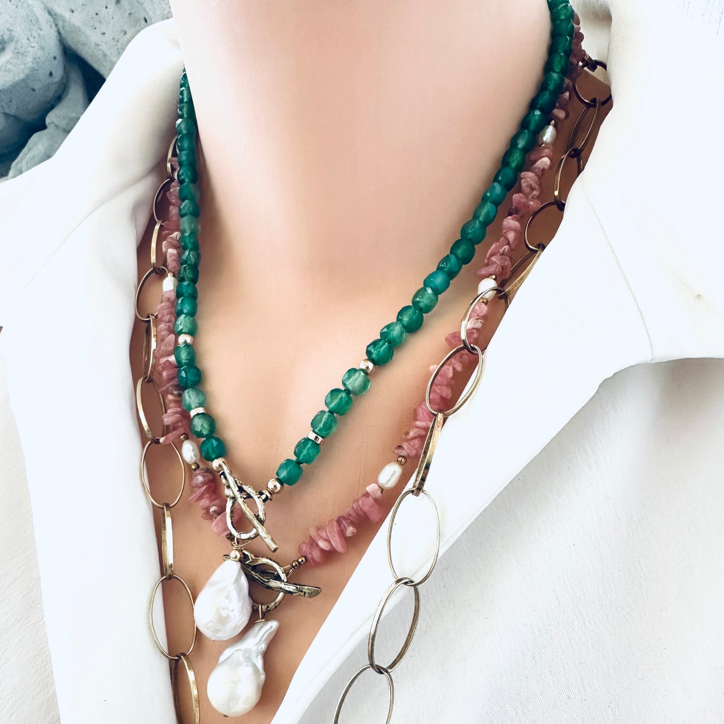 Rhodochrosite pearl toggle necklace layered with other necklaces showing versatility of toggle design