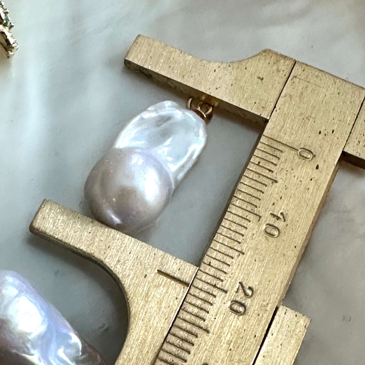Citrine stud earrings with pearl drops measured beside ruler for size reference