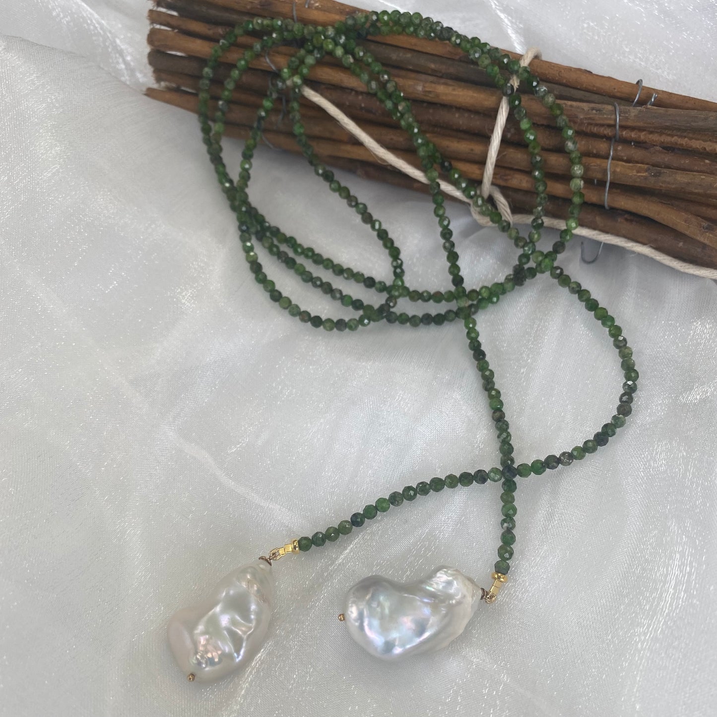 Green diopside lariat necklace with Baroque pearls showcasing vibrant green gemstones and elegant freshwater details.