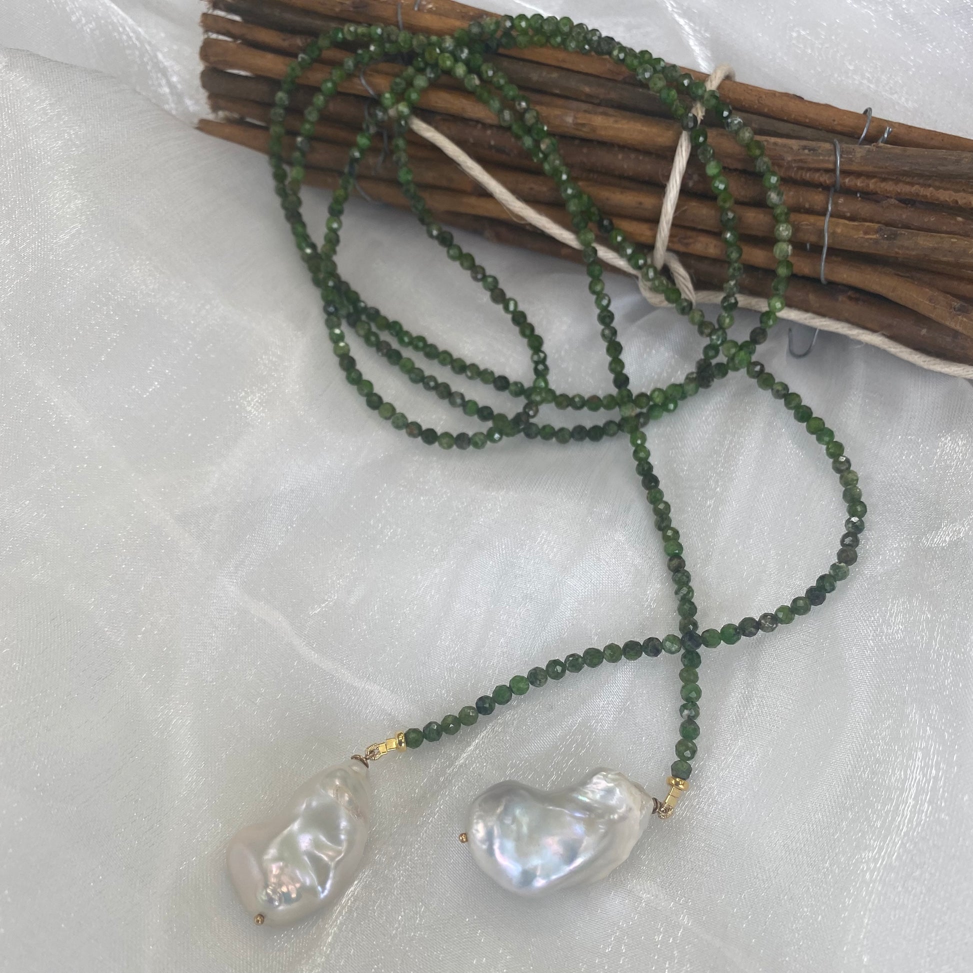 Green diopside lariat necklace with Baroque pearls showcasing vibrant green gemstones and elegant freshwater details.