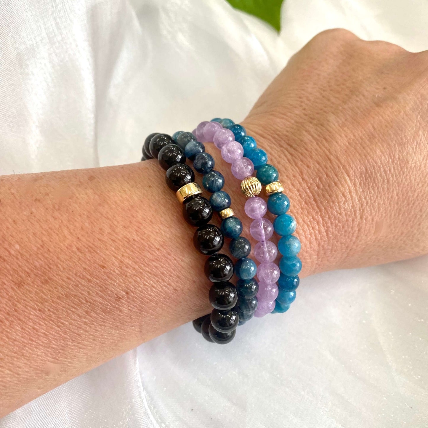 Lavender amethyst stretch bracelet showcased with other bracelets on a wrist, highlighting its elegant design.