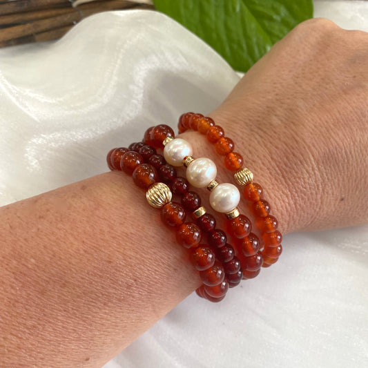 Orange Carnelian Bracelet worn with other bracelets on woman’s wrist – lifestyle shot