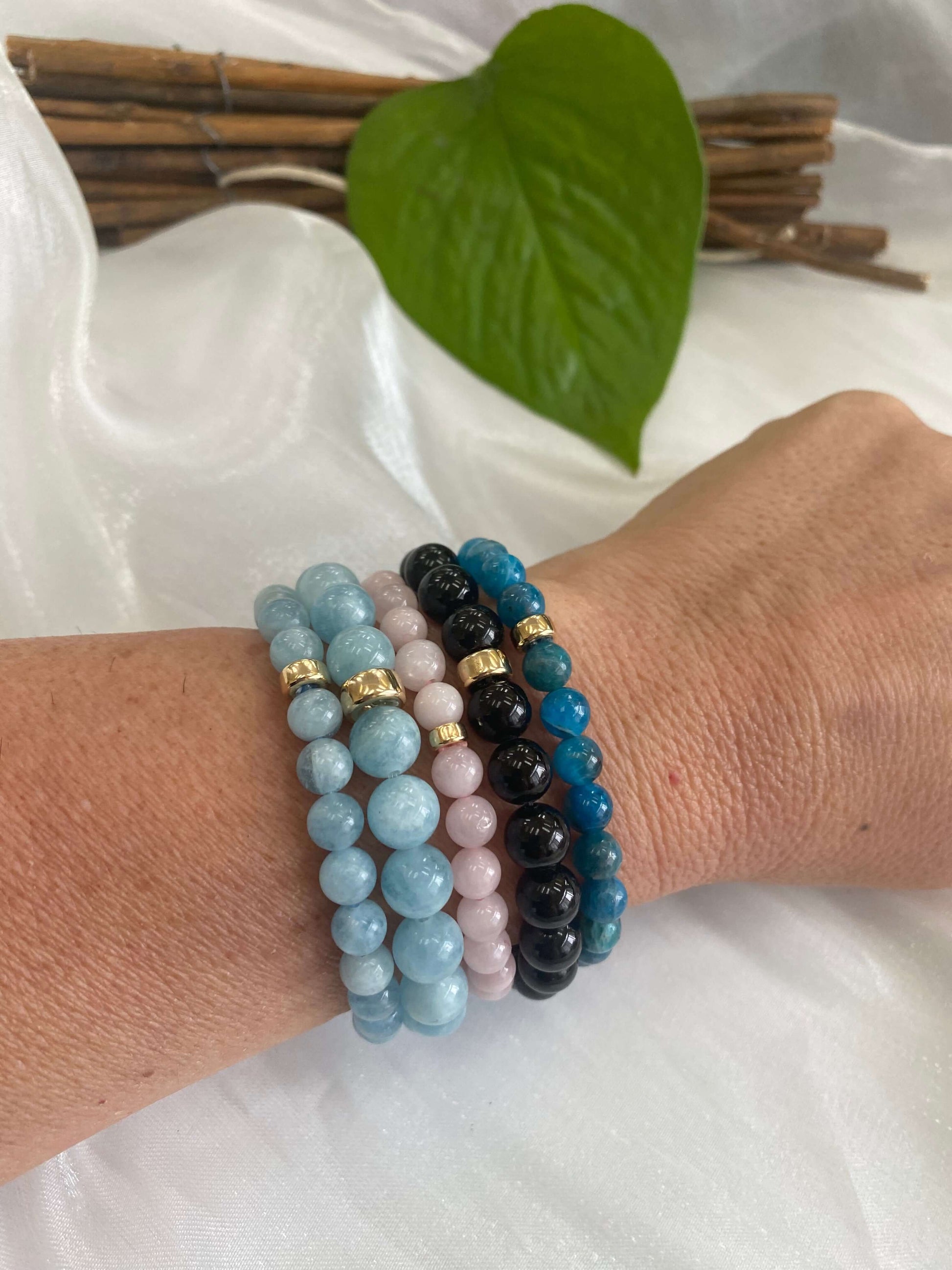 Aquamarine stretch bracelet in various colors, 6mm and 8mm beads, featuring gold filled accents on a wrist.