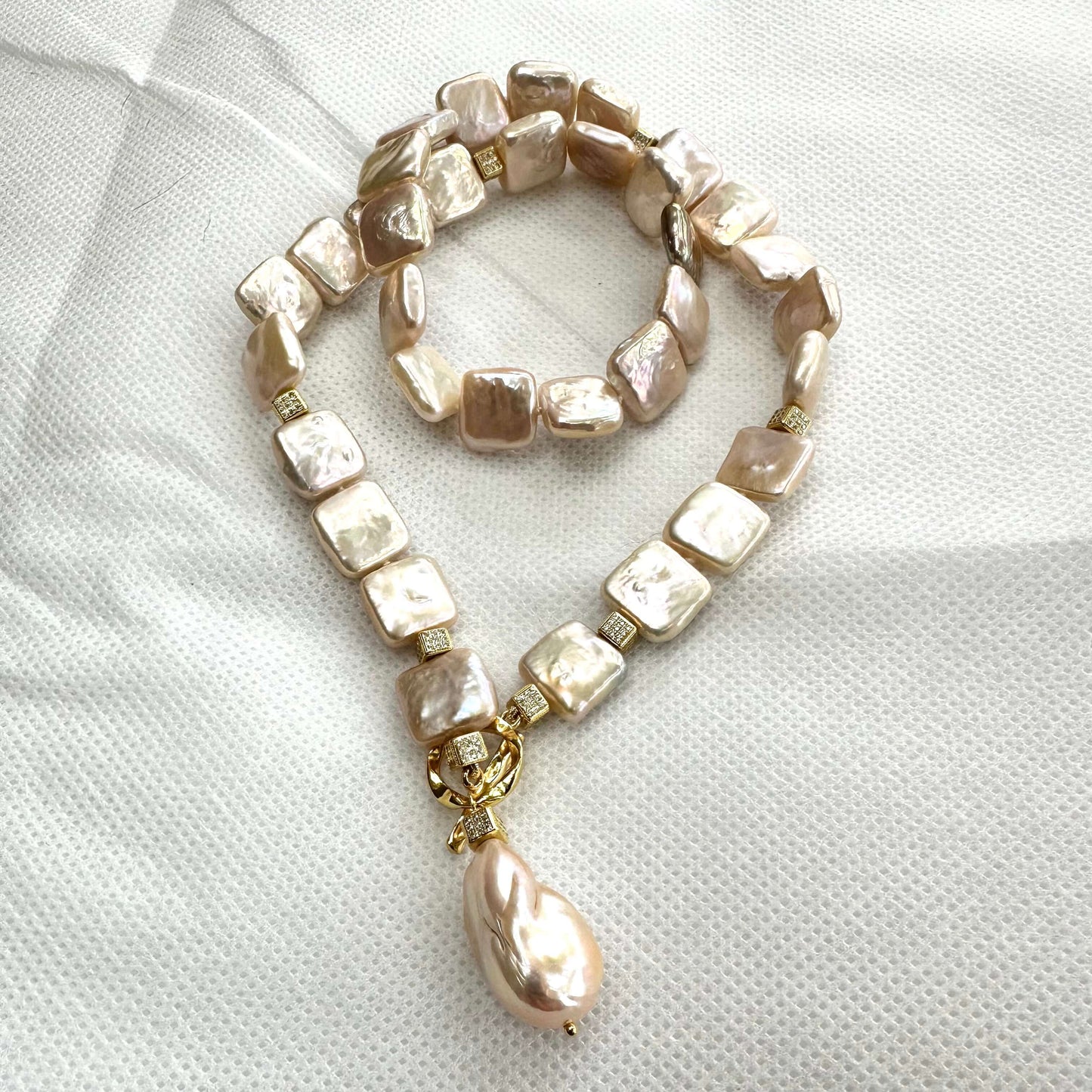 Full view of golden baroque pearl toggle necklace on white backdrop — handcrafted statement jewelry featuring square pearls and gold clasp