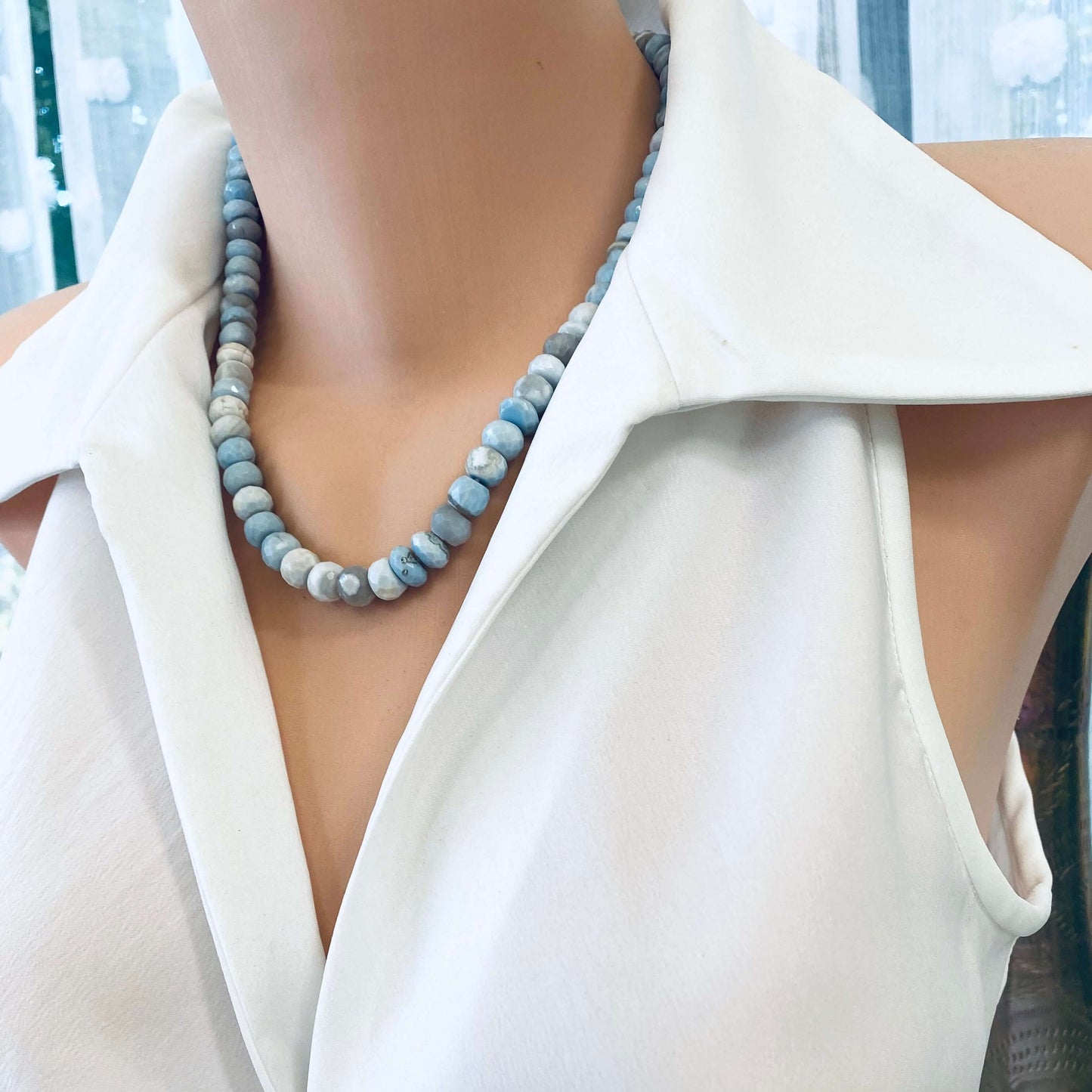 Side close-up of blue grey opal necklace on mannequin showing faceted candy design