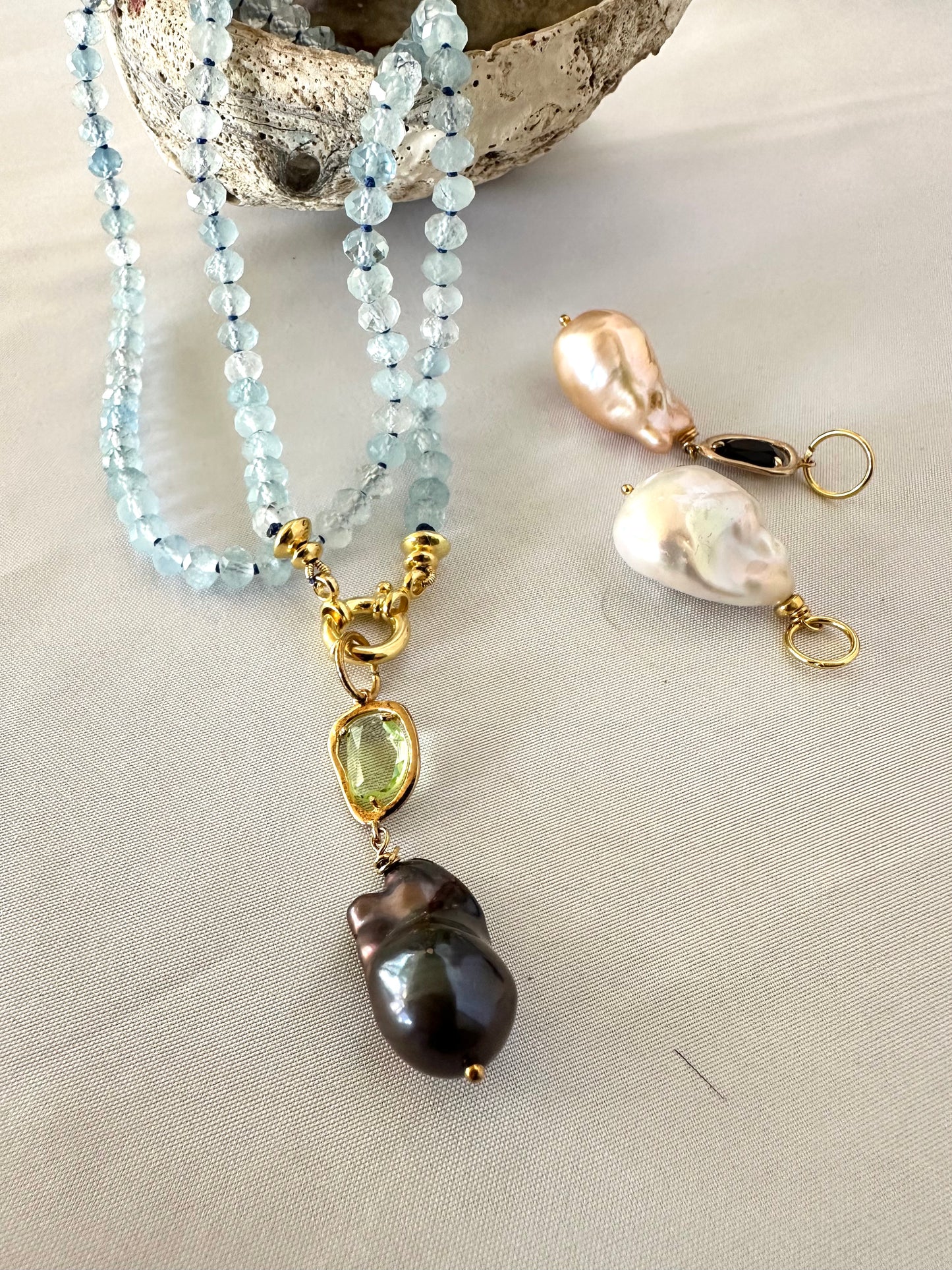 Aquamarine baroque pearl necklace with blue beads and pearl pendants, showcasing elegant design and calming glow.