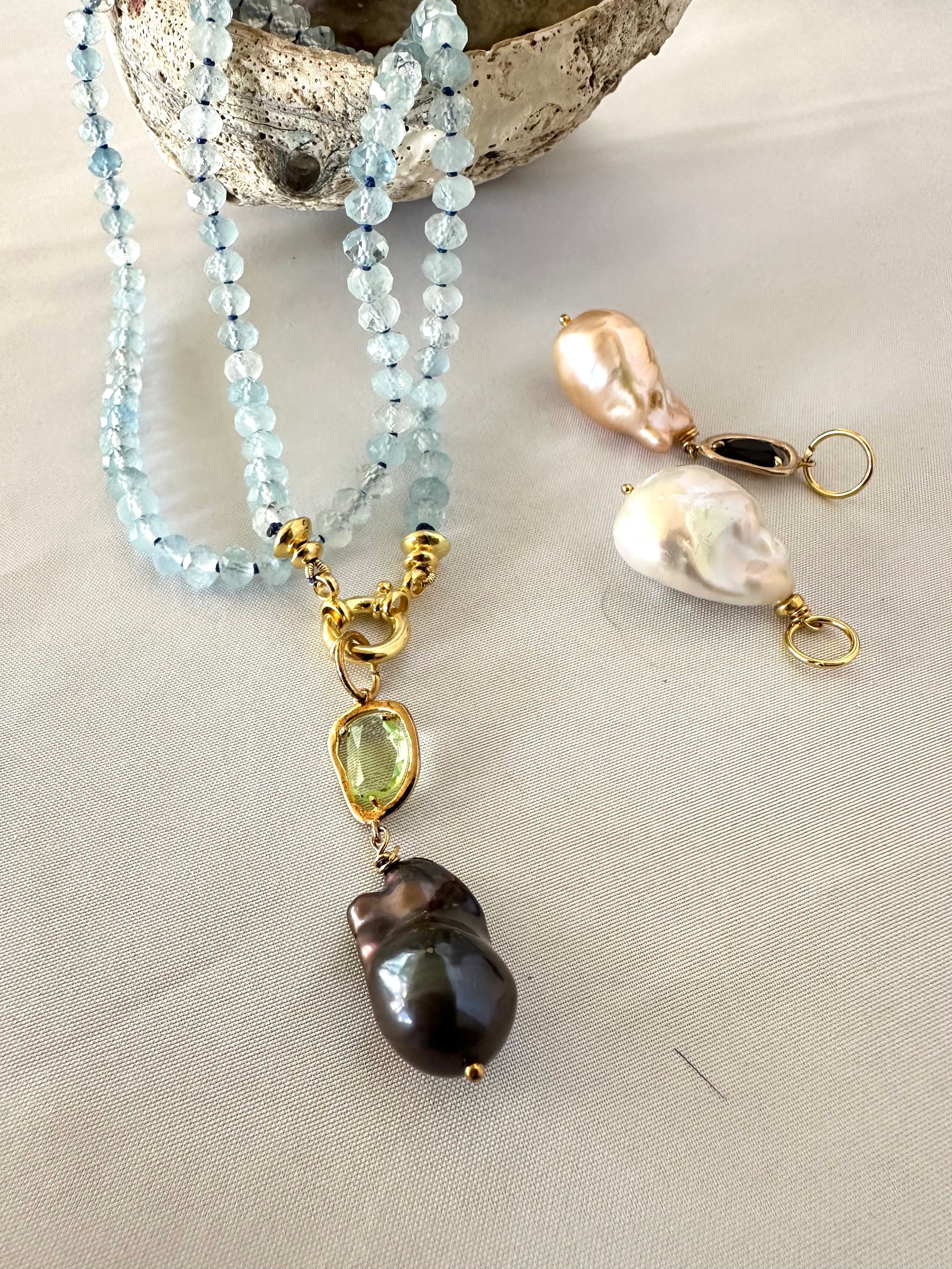 Aquamarine baroque pearl necklace with blue beads and pearl pendants, showcasing elegant design and calming glow.