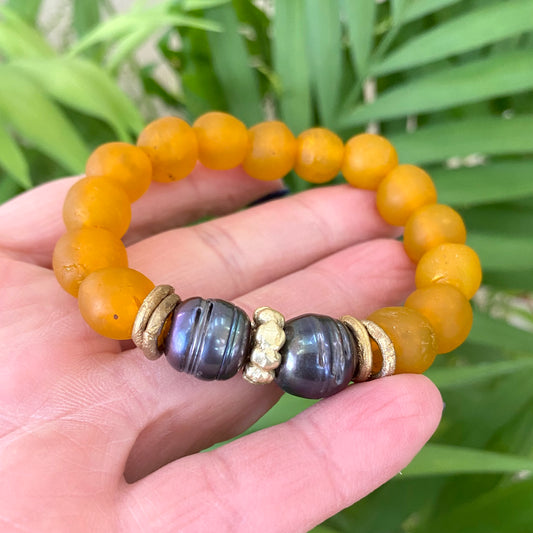 Black pearl bracelet featuring tangerine African recycled glass beads, showcasing vibrant colors and ethical craftsmanship.