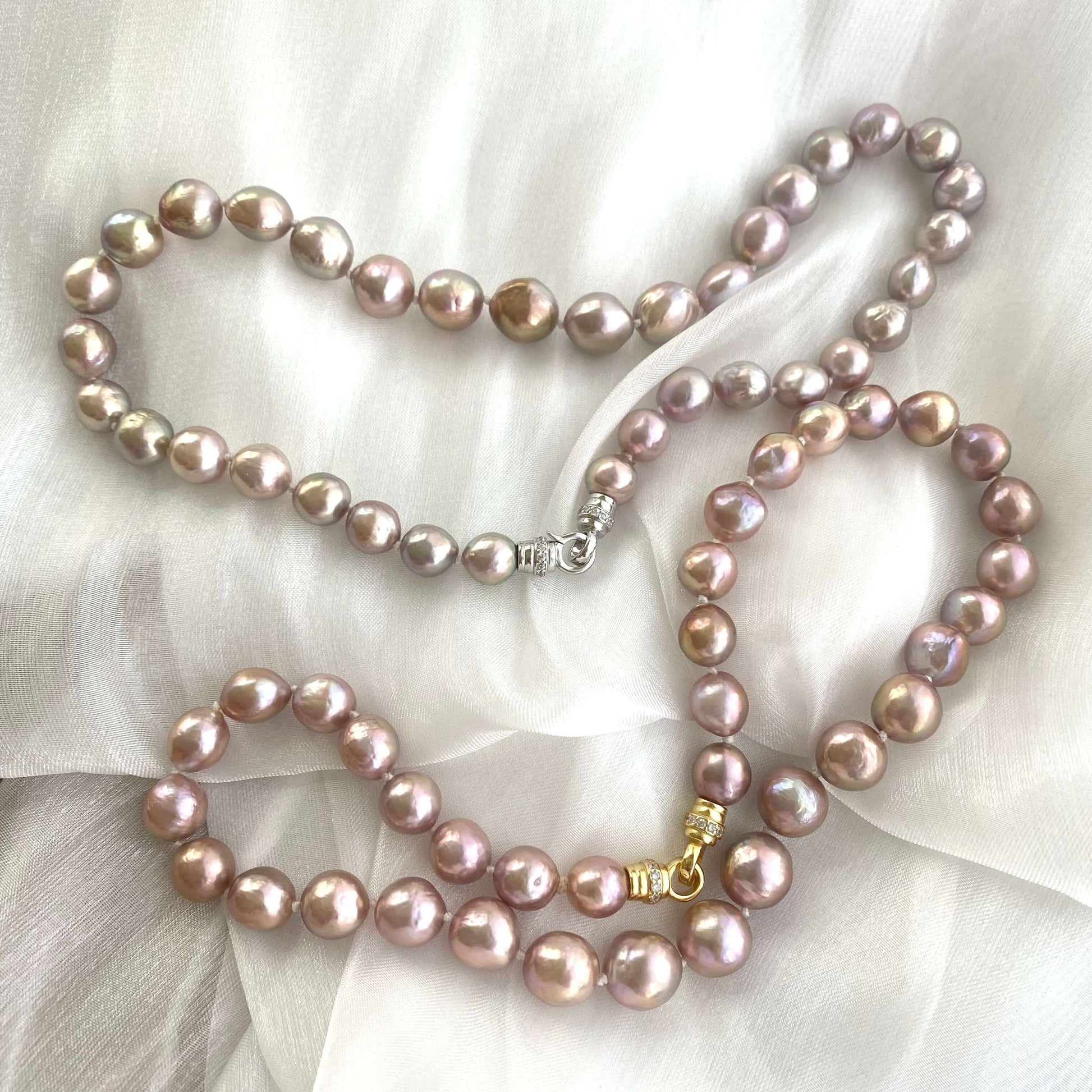 Two pink lavender pearl necklaces with slightly different lusters displayed on white cloth, showing natural variation.