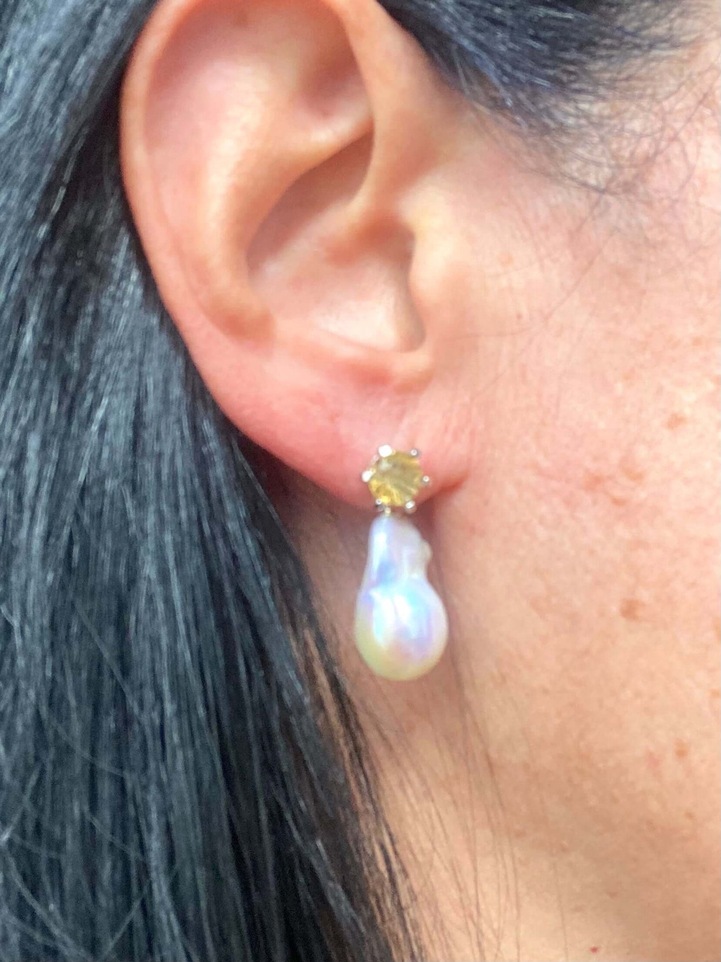 Side view of woman wearing citrine stud earrings with removable pearl drops
