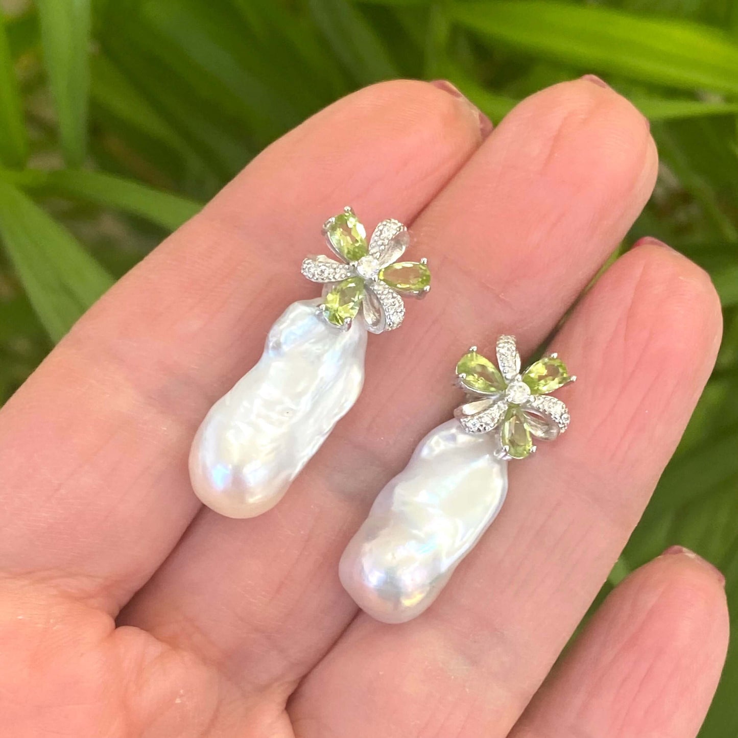 Handcrafted Peridot stud earrings with baroque pearl drops held in hand