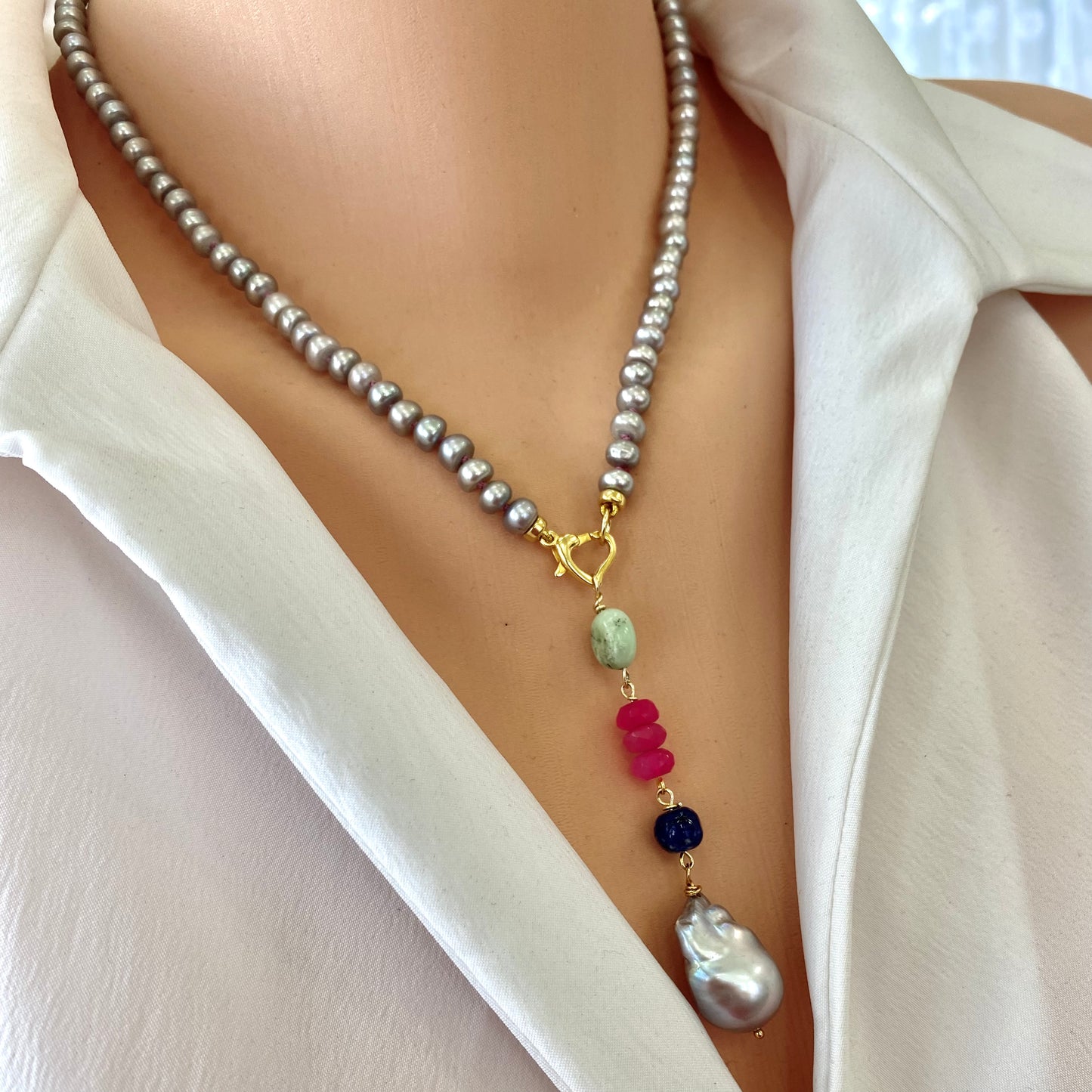 Grey pearl necklace with removable pendant worn on model featuring baroque pearl and gemstones