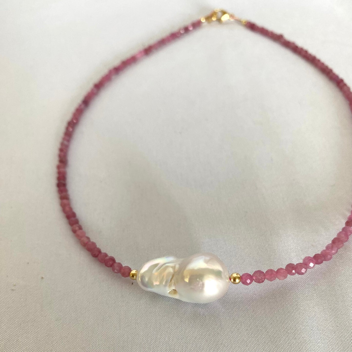 Pink Tourmaline Baroque Pearl Necklace with shimmering pink tourmaline beads and a unique baroque pearl centerpiece.